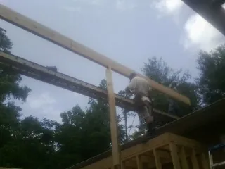 Carpenter setting a ridge beam over a new addition frame — Ice Dam Removal by Roofing Brothers in Walworth