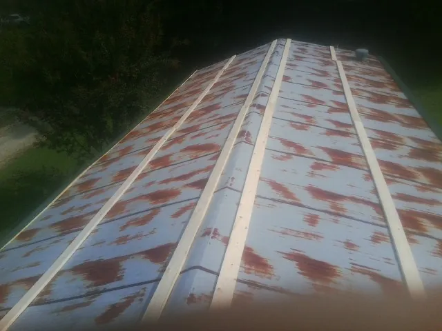 Rusted metal roof panels with new wood purlins before replacement — Storm Damage Roof Repair in Walworth by Roofing Brothers