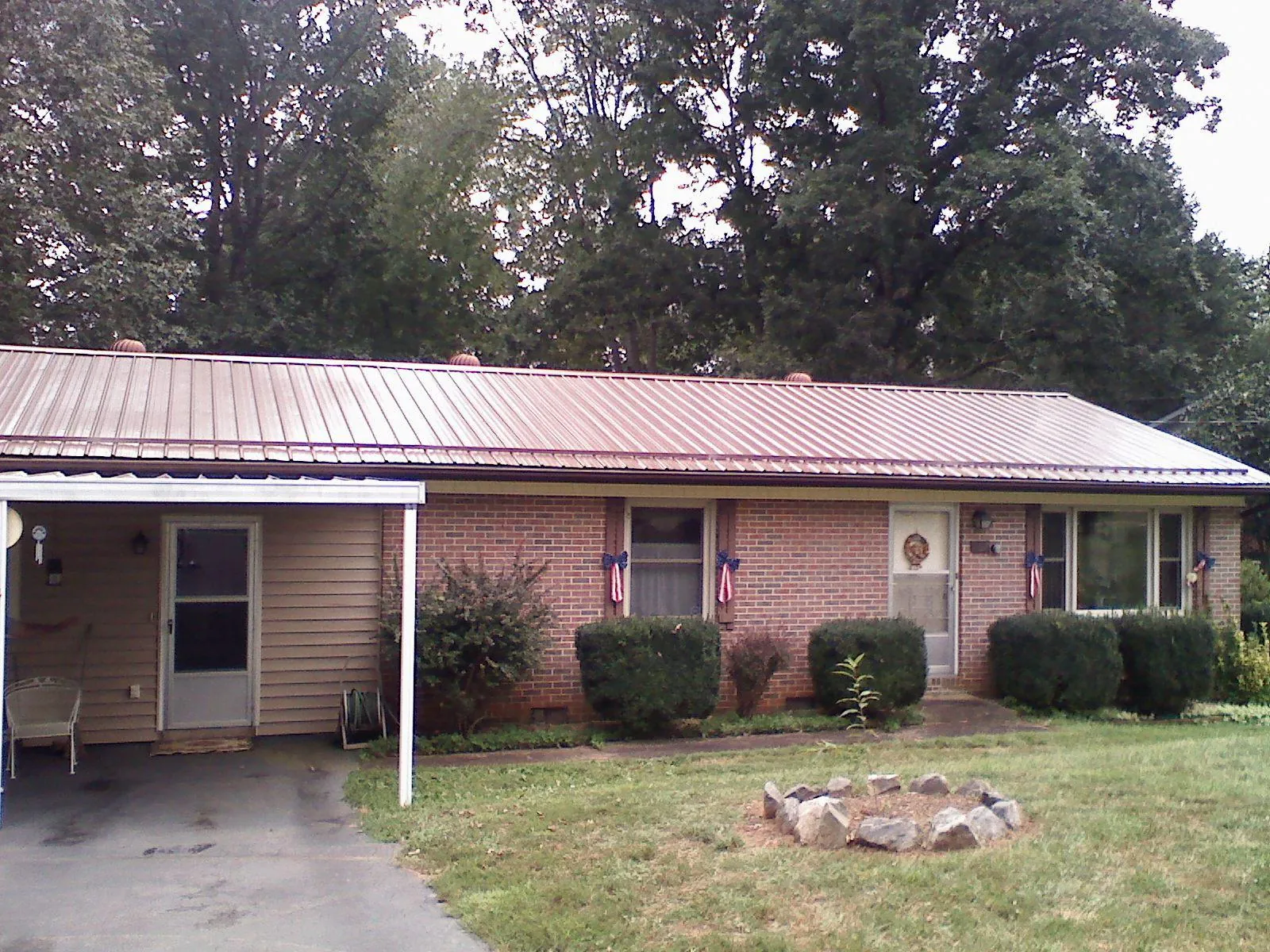 Bronze metal roof and carport on a brick ranch home — Roof Repair work by our crew in Walworth